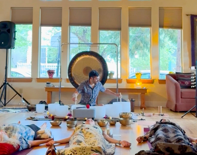 Zach Lee playing the gong during a group sound bath.