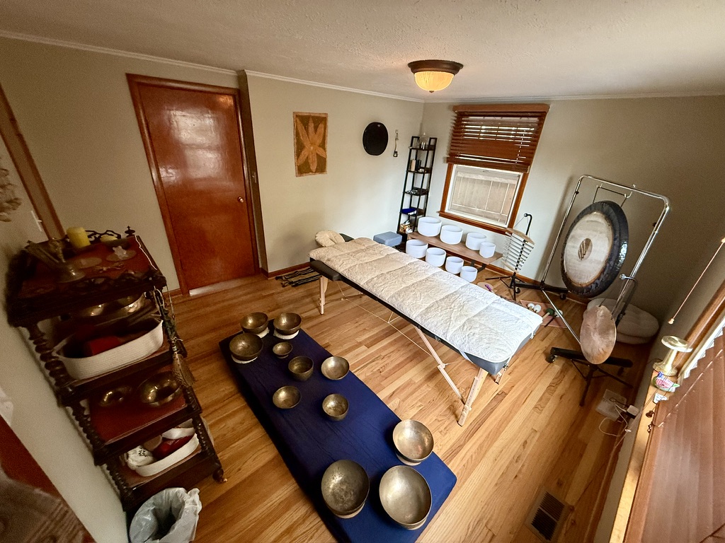 The Sonic Kindness studio set for a private session - massage table, gong, and singing bowls.